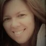 A woman smiling for the camera with long hair.