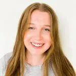A girl with long hair smiling for the camera.