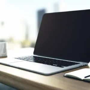 A laptop sitting on top of a wooden desk.