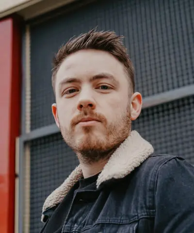 Man with beard wearing denim jacket.