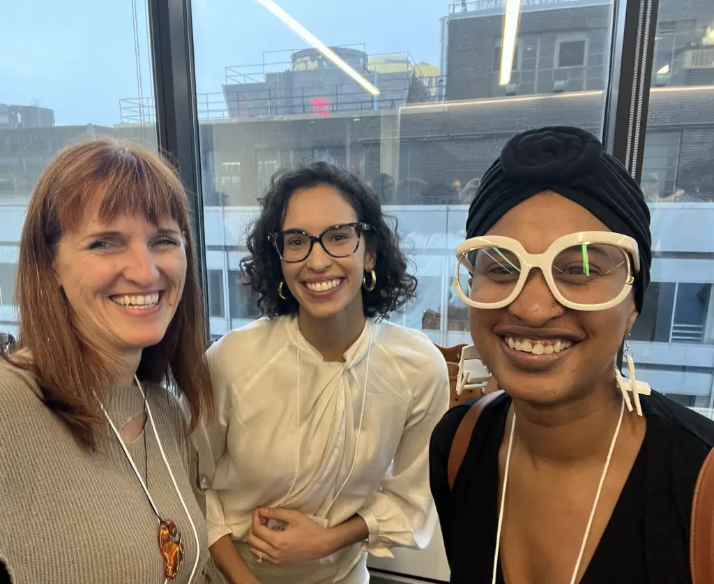 Three women smiling for a photo.
