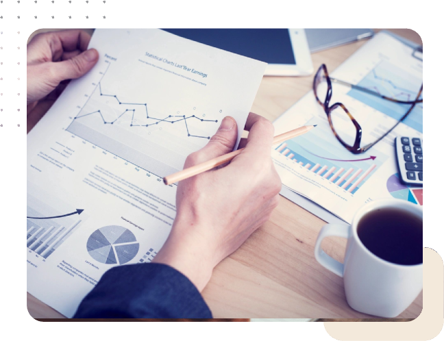 Person analyzing graphs and charts with coffee.