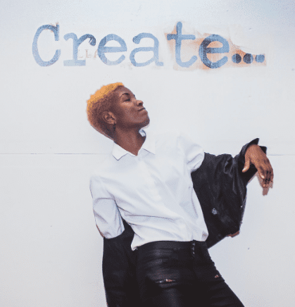 A person standing in front of the word create.