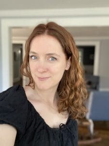 Woman with wavy hair in black top.