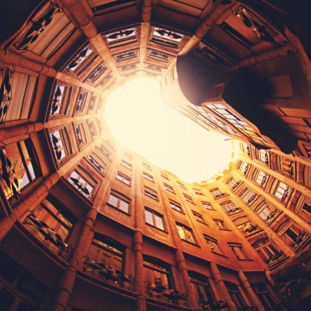 Looking up at a sunlit architectural courtyard.