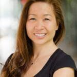 A woman with long brown hair wearing black shirt.