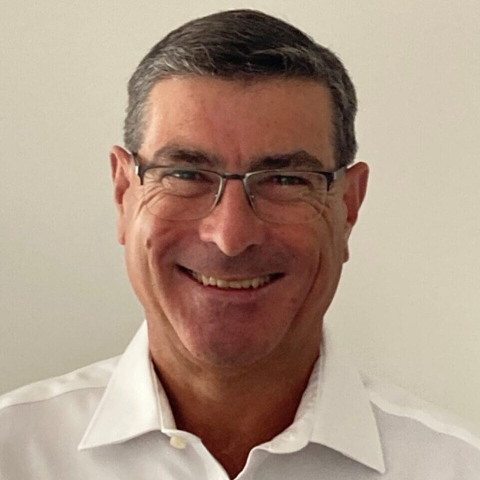 Headshot of a smiling man in glasses.