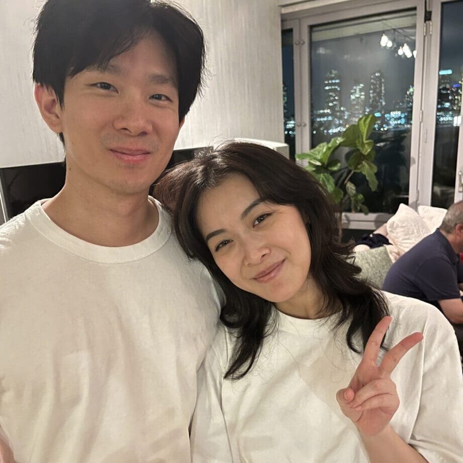 Happy couple in white shirts, peace sign.