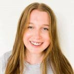 A girl with long hair smiling for the camera.