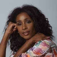 Woman posing in colorful patterned blouse.