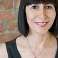 A woman with black hair and wearing a necklace.