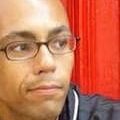 A man with glasses is looking at the camera.