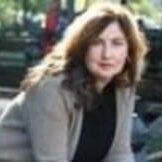 Woman sitting outdoors in a park.